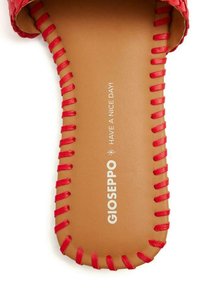 Sandalo scivolato rosso intrecciato con una parte superiore testurizzata, soletta color tan e cuciture decorative rosse. Nome del marchio "GIOSEPPO" stampato sulla soletta.