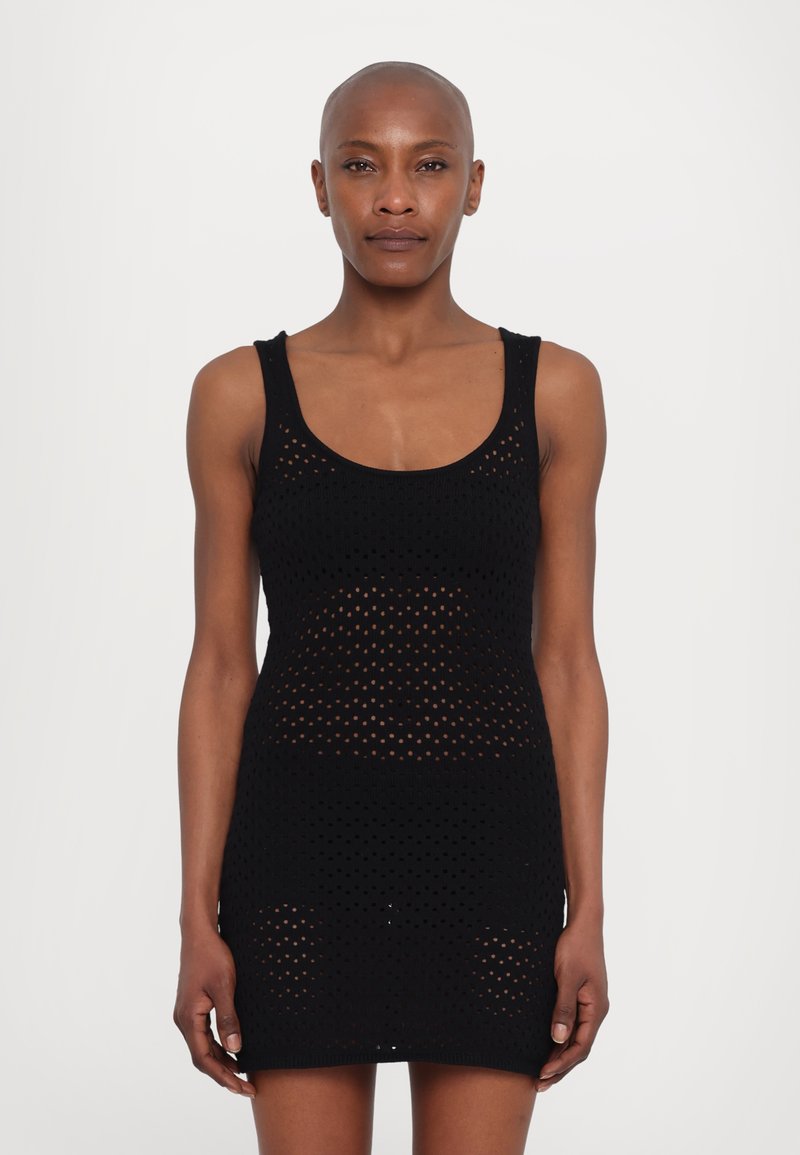 Rochie mini tricotată neagră cu decolteu rotund, având un model perforat pe întreaga suprafață și marginile ajurate la tiv și la gura de braț.