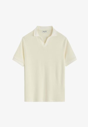 Polo en maille à manches courtes de couleur crème avec une petite ouverture en V et un col souple, présenté sur un fond blanc.