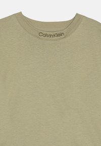 Olivengrønn crewneck T-skjorte laget av glatt bomullsstoff, med en sydd halslinning og "Calvin Klein"-logoen i subtil brodering.