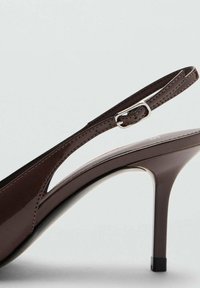 Sandale cu toc înalt din piele patent maro, cu design slingback, cataramă ajustabilă și toc subțire stiletto. Textură netedă și lucioasă.