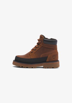 Brun og sort læderankelstøvle med polstret krave, snørelukning foran, robust sål og Timberland trælogo på hælen.