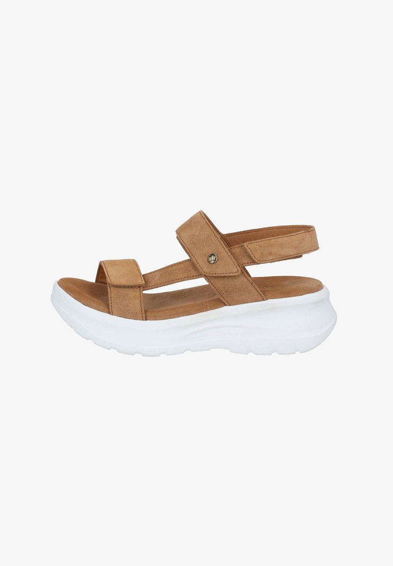 Sandalias de ante marrón con dos correas anchas y una suela gruesa blanca. Presenta un pequeño acento metálico en una de las correas. Diseñadas para la comodidad.