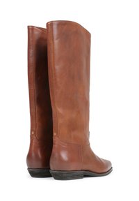 Botas marrones de cuero hasta la rodilla con una textura suave, punta redonda y tacón bajo apilado; presentan detalles en dorado cerca de las costuras.