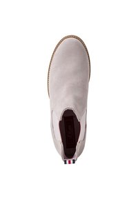 Světlé šedé semišové slip-on boty s elastickými postranními akcenty, zaobleným špičkou, hnědou gumovou podrážkou a červenou, bílou a modrou pruhovanou poutkou na patě.
