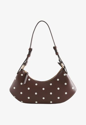 Braune halbmondförmige Handtasche mit weißen Punkten, goldenem Reißverschluss und verstellbarem Schulterriemen mit Schnallendetails.