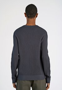 Maglione a coste grigio scuro con maniche lunghe, scollatura rotonda, orlo arrotondato e materiale testurizzato. La vista posteriore mostra dettagli lungo le spalle.