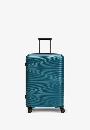 Hard-shell teal koffer met gestructureerde diagonale ribbels, vier draaiwielen en een zwarte telescopische handgreep die is uitgeschoven.