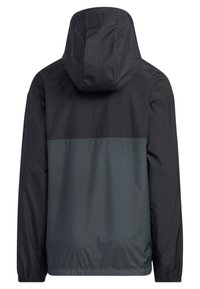Chaqueta impermeable en negro y gris oscuro. Cuenta con una capucha, puños elásticos y un dobladillo recto. Textura suave con un diseño de bloques de color.