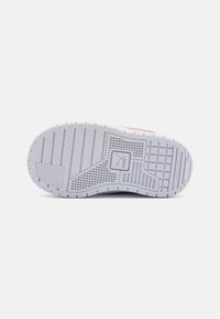 Hvit gummisåle til sneakers med et teksturert grep mønster og et sentralt logo. Glatt, ikke-merket overflate med horisontale og vertikale linjer.