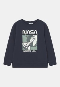 Tmavě modrá mikina s dlouhými rukávy, se znakem NASA a textem: "PLANETA TĚ POTŘEBUJE" a stylizovanou ilustrací rakety.