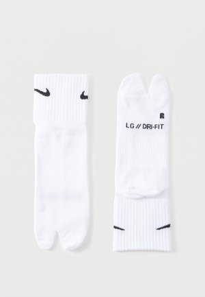 Paar weiße Nike Split-Toe-Socken mit schwarzen Swoosh-Logos, LG-Größenetikett und Dri-FIT-Schriftzug auf einfarbigem Hintergrund.