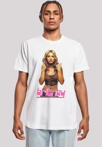 Witte katoenen T-shirt met een grafische print van een vrouw met lang blond haar, die een bruine top draagt, en de tekst "britney" in het roze.