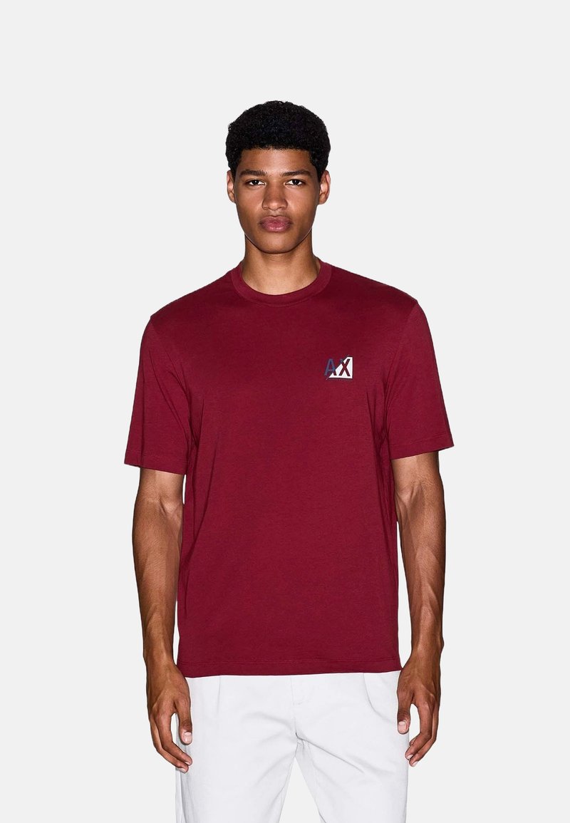 Bordeaux-rode T-shirt met korte mouwen van katoen. Bevat een klein logo op de linkerkant van de borst, met een ronde halslijn en een normale pasvorm.
