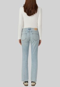 Helle blaue, ausgebogene Jeans aus Denim mit einer ausgewaschenen Optik, Fünf-Taschen-Design, braunem Lederpatch auf der Rückseite und dezenten Steppnähten.