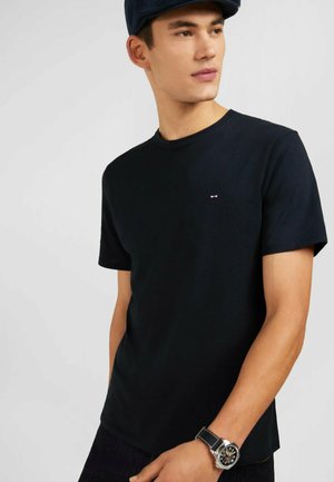 T-shirt en coton noir à manches courtes et col rond. Présente un petit logo sur la poitrine. Le tissu semble lisse et léger.