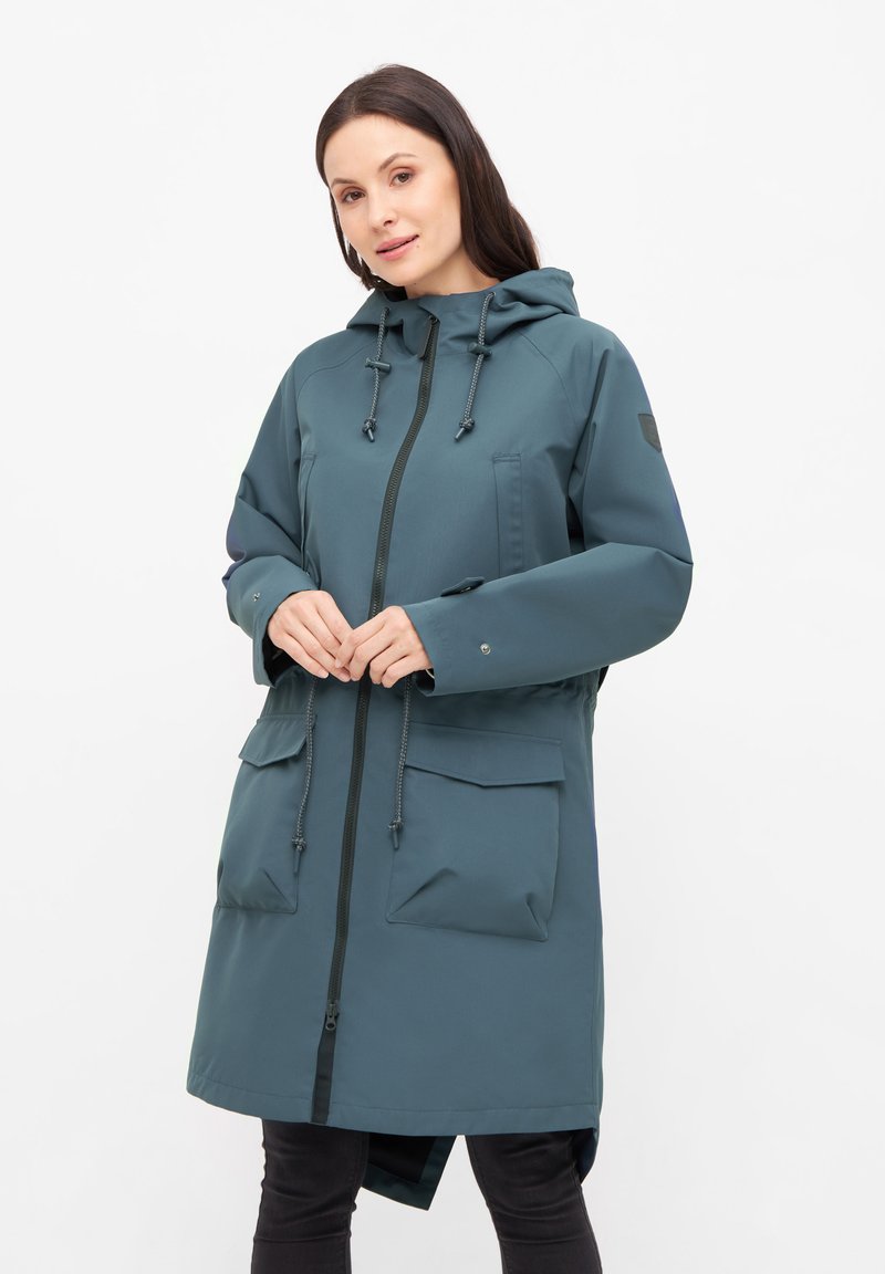Waterafstotende parka in donker teal, met een rits aan de voorkant, een verstelbare capuchon en meerdere zakken aan de voorkant. Soepele textuur, middellange ontwerp.