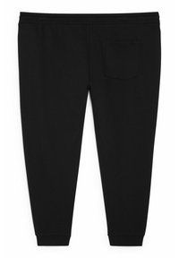 Czarne spodnie dresowe zwężane, z elastycznym paskiem, ściągaczami przy kostkach oraz pojedynczą kieszenią z tyłu po prawej stronie.