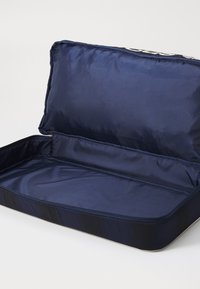 Mørkeblå rektangulær stoffveske med en glatt, skinnende innside, og med glidelås-lukking uten eksterne rom.