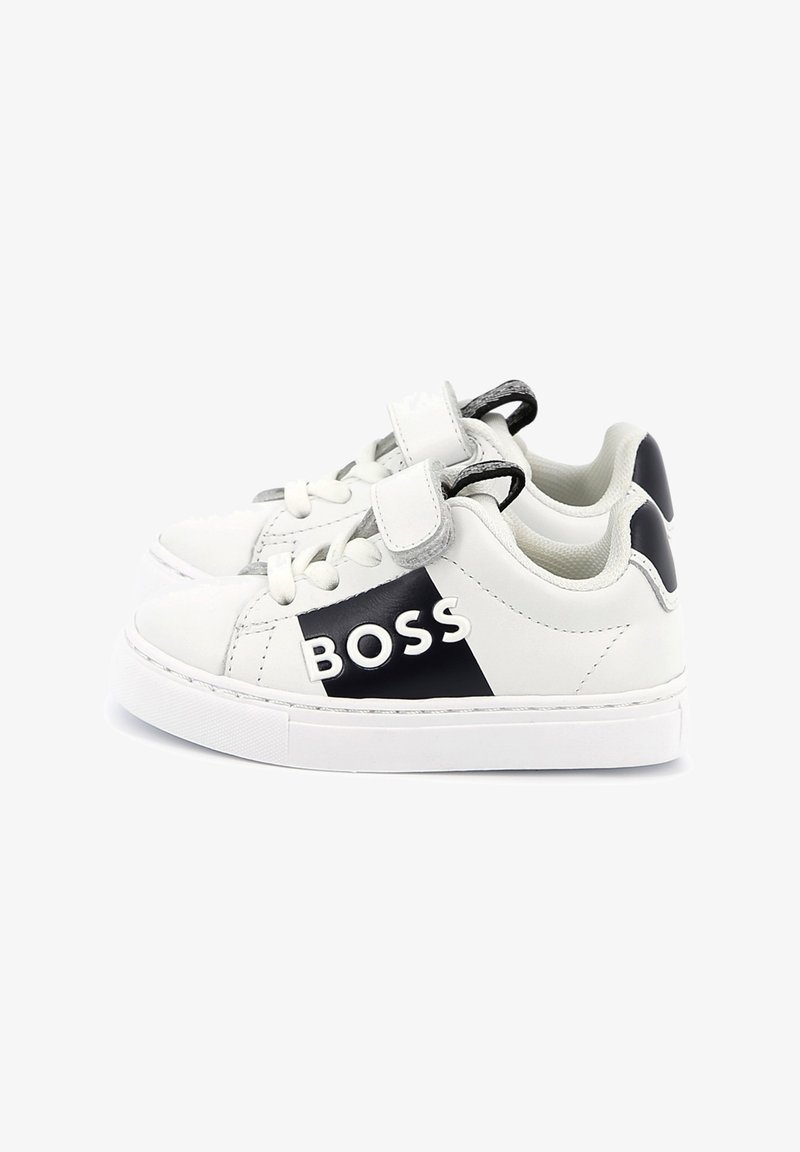 Baskets en cuir blanc avec accents noirs, dotées d'une sangle velcro, d'une surface texturée et du logo 'BOSS' sur le côté. Bout arrondi et semelle blanche.