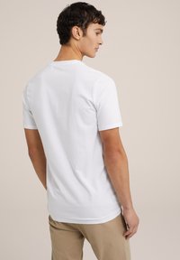 Witte kortom mouw t-shirt van katoen, met een ronde halslijn en een soepele textuur, in combinatie met beige broek voor een casual look.