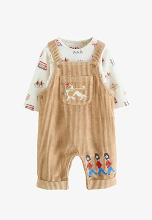 Beež corduroy beebikombe tikitud koera ja kolme marssiva valvuriga, millele on lisatud valge pika varrukaga särk Londoni-teemaliste trükkidega.