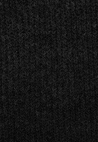 Textured black fabric with a knit pattern, displaying a fuzzy and slightly uneven surface, indicating warmth and softness.
