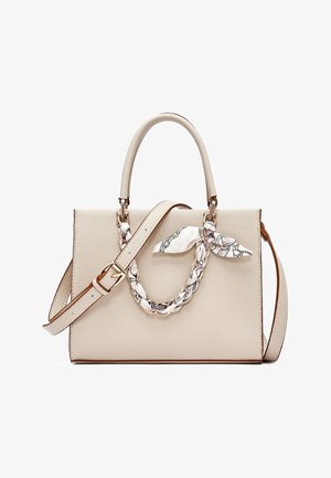 Bolso de mano color crema con textura, asa superior, correa de hombro ajustable y pañuelo trenzado atado a una de las asas.