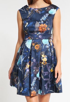 Ærmeløs mørkeblå kjole med en figursyet talje og plisseret nederdel, der har et livligt blomsterprint i orange, blå, gule og lilla toner.