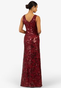 Abito da sera in sequins bordeaux con silhouette aderente, motivo floreale e scollatura a V sul retro. Lunghezza fino al pavimento e senza maniche con chiusura a zip.