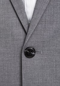Grauer Blazer aus strukturiertem Stoff, mit einem einzelnen schwarzen Knopfverschluss und einem Reverskragen-Design. Innenausstattung zeigt weißen Futter.