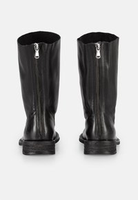 Schwarze Lederstiefel bis zum Knie mit einem Reißverschluss auf der Rückseite, flachen Sohlen und einer glatten Textur. Einfaches Design, keine zusätzlichen Verzierungen.