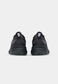Black athletic shoes with a soft, textured upper, featuring a padded collar, reflective accents, and a durable rubber outsole.