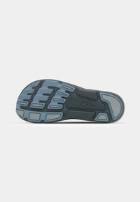 Shoe sole featuring a black rubber base with textured patterns and blue accents, designed for grip and traction.