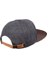 Chapeau en tissu gris avec une surface texturée et une sangle en cuir marron. L'envers de la visière présente un motif circulaire dans une teinte plus sombre.