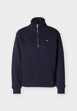 Marineblaues Sweatshirt mit langen Ärmeln, hohem Kragen und halbem Frontreißverschluss, mit einem kleinen gestickten Logo auf der linken Brust.