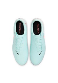 Heledad sinine sünteetiline jalgpallijalats, millel on tekstureeritud pind, must Nike'i swoosh, roosa aktsent ja nöörid; sees on "PHANTOM GX" brändingu tekst.