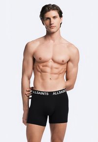 Czarne bokserki z czarno-białym paskiem w talii z napisem "ALLSAINTS"; miękki materiał o dopasowanym kroju; model z muskularną sylwetką.