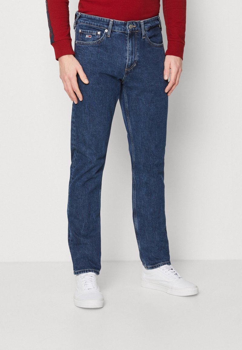 Mörkblå denimjeans med rak benpassform, femficksdesign och subtila sömnadsdetaljer. Matchat med vita sneakers.