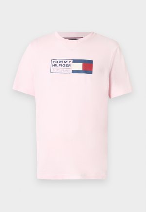 Lyserød bomuld T-shirt med V-udskæring, med et rektangulært motiv i marineblåt og rødt med teksten "TOMMY HILFIGER" og logo. Korte ærmer.