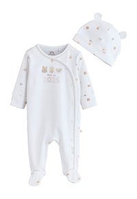 Vit babypyjamas och matchande mössa med små djurtryck och texten "born in 2026" på framsidan av pyjamasen.