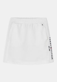 Vit bomullsblandad kjol med elastisk midjeband, sidofickor och "TOMMY HILFIGER EST. 1985" logotyp tryckt i marinblått och rött på ena sidan.