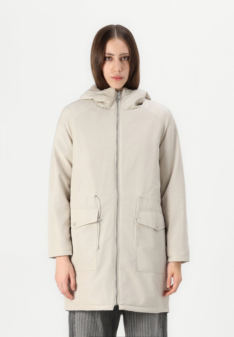 Lysbeige parka med glidelås foran, justerbar hette, to frontlommer og en jevn tekstur. Har snor ved livet.