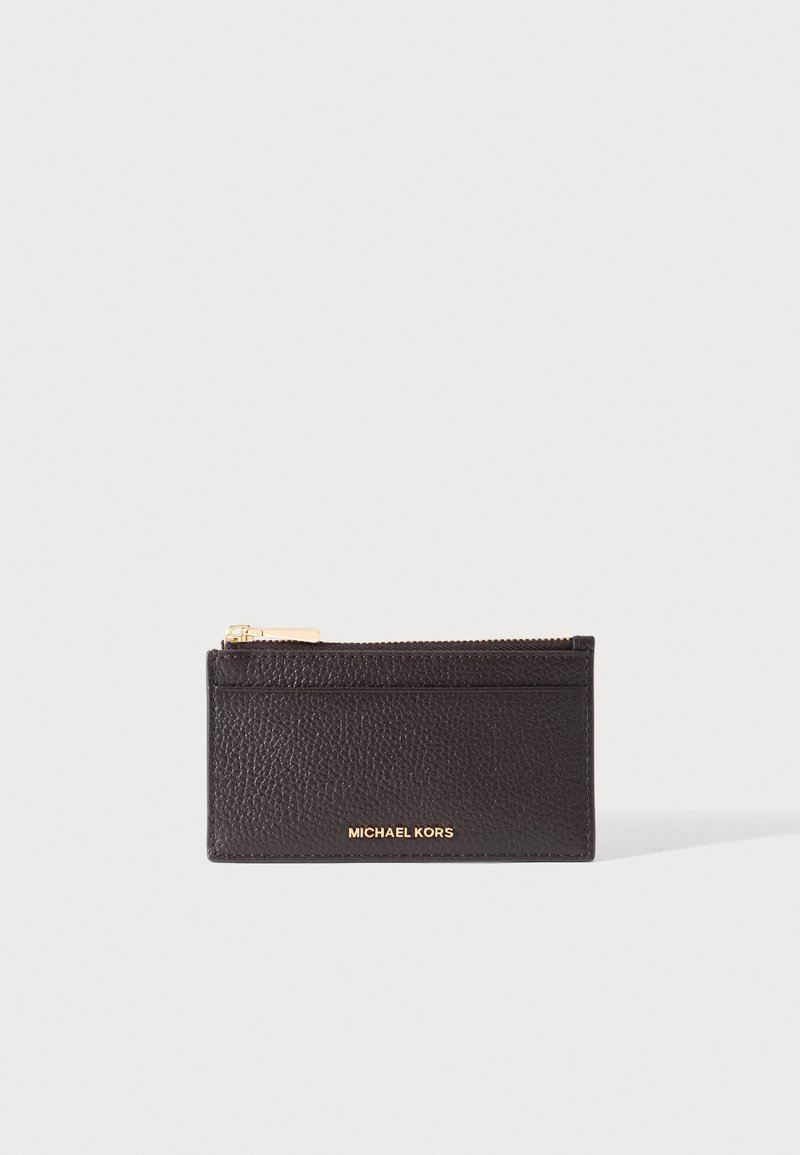 Porte-cartes en cuir noir texturé avec zip doré en haut et logo "Michael Kors" doré à l'avant sur fond blanc.