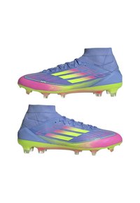 Lightweight soccer cleats in gradient blue, pink, and yellow. Features a low-cut design, textured upper, and translucent studs for grip.