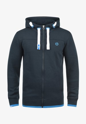 Ciemnoniebieska bluza z kapturem na zamek z białymi akcentami i niebieskim logo. Wykonana z miękkiego materiału, z prążkowanymi mankietami i dolnym obszyciem.