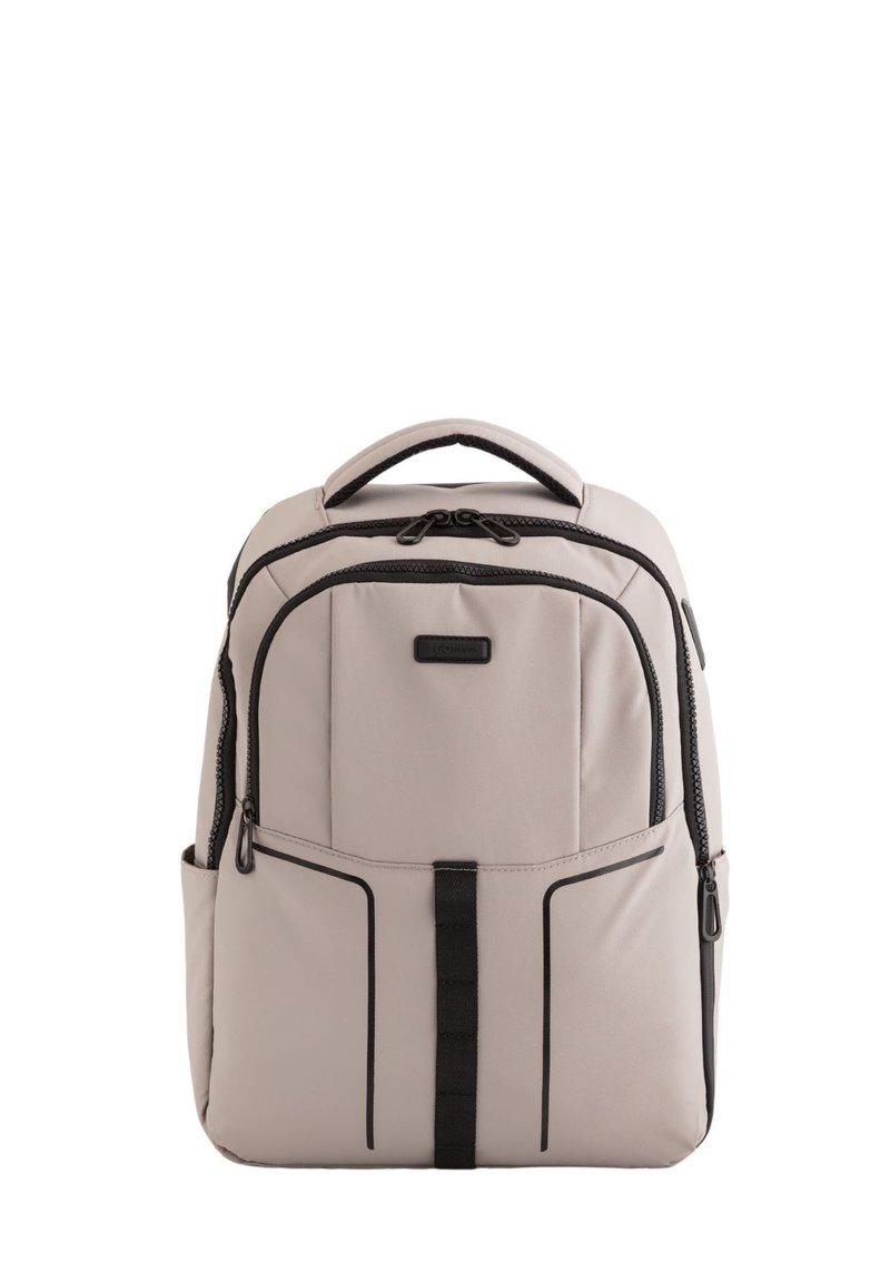 Mochila beige fabricada en tela, con acentos negros, un asa en la parte superior, múltiples compartimentos con cremalleras y bolsillos laterales para almacenamiento.