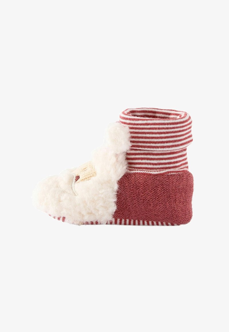 Chaussette bébé douce conçue comme le Père Noël avec des rayures rouges et blanches et une barbe blanche et duveteuse à l'avant.