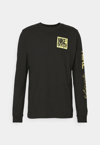 Maglietta a maniche lunghe nera con logo giallo "NIKE hoops" sul petto e testo giallo "NIKE hoops" lungo la manica destra.