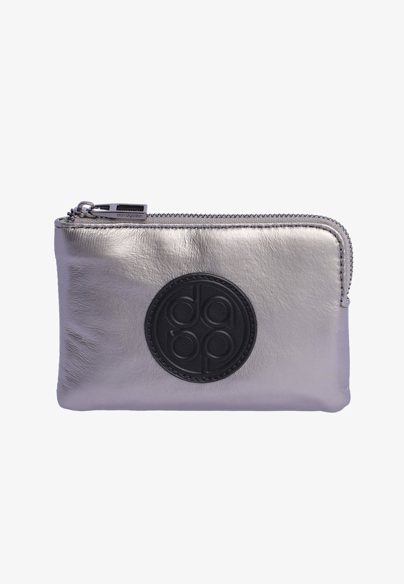 Cartera de cuero metálico plateado con un logo circular negro, cierre de cremallera y textura suave. Forma rectangular compacta con detalles de costura.